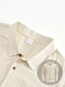 Detail of men's linen shirt collar and size M tag showing fabric texture and buttons