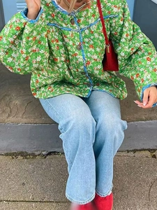Close-up of green floral quilted cotton jacket featuring vintage brown buttons and blue lining