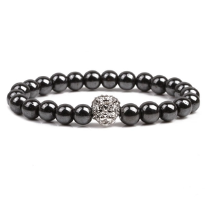 Macro shot of natural black stone beads featuring a silver lion head charm on the bracelet