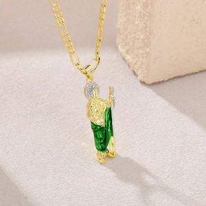 Macro shot of gold St. Jude pendant with green enamel robe and silver halo details