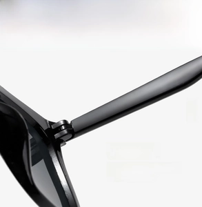 Close-up of the durable metal hinge and sleek black frame assembly on sunglasses