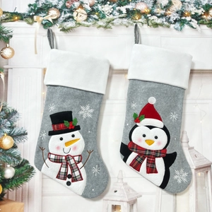 Detailed view of grey felt Christmas stockings with 3D snowman and penguin embroidery