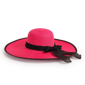 Detail of fuchsia wide-brim straw sun hat featuring black ribbon bow and woven texture