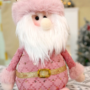 Close-up of pink Santa plush with sequined fabric, white beard, and golden belt buckle