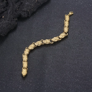 Detailed top view of gold punk snake bracelet with textured chain on dark rock