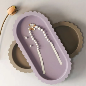 Detailed close-up of a white beaded jewelry set with floral charms in a scalloped tray