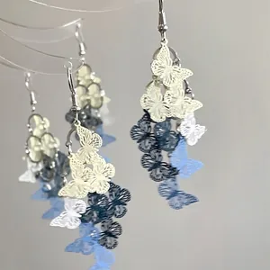 Detail of layered resin butterfly tassel earrings with blue and yellow color palette
