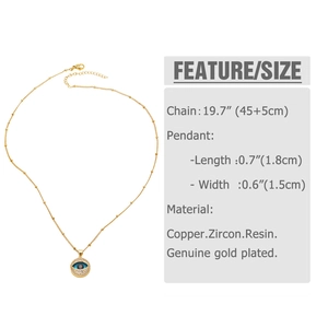 Macro detail of gold plated heart pendant with blue evil eye and zircons on bead chain