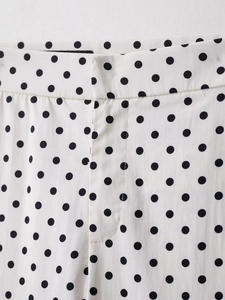 Detail der Taille und des Reißverschlusses der weißen gepunkteten Mini-Schlaghose mit Steppnaht