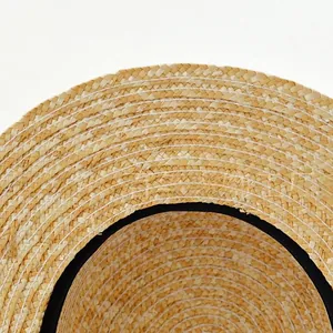 Close-up of natural straw weave texture and internal black ribbon sweatband detail