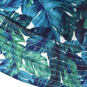 Macro shot of tropical leaf print bucket hat with durable stitching detail on the brim