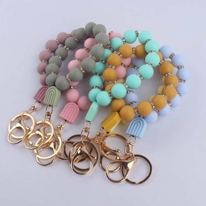 Colorful silicone bead keychain wristbands with gold metal rings and rainbow charms