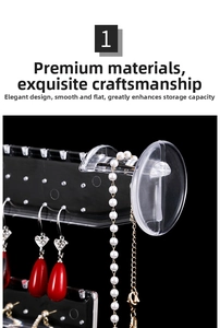 Transparent acrylic jewelry display stand showing red drop earrings and necklaces