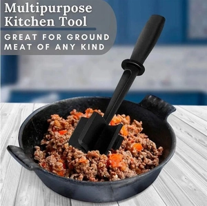Black meat chopper mashing ground beef with carrots in a heavy iron skillet