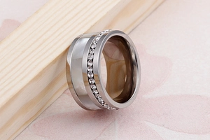 Dettaglio di un anello largo in argento con inserto in madreperla e fila di cristalli chiari
