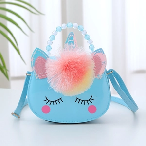 Detail of light blue unicorn purse with beaded handle and colorful pom pom keychain