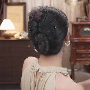 Elegant black double-layered satin bow hair claw with beads on a French bun hairstyle
