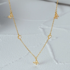 Close-up of S925 silver butterfly necklace with five gold plated zircon charms