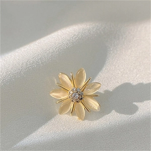 Macro shot of elegant daisy brooch with yellow opal petals and sparkling zircon center