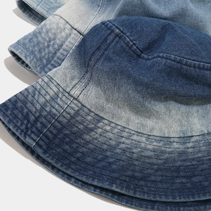 Detailed macro view of denim bucket hat stitching and washed vintage fabric texture