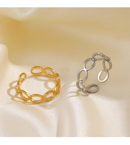 Macro view of hollow oval geometric rings in gold and silver on silk fabric