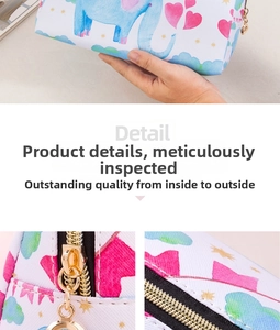 Detail of white PU leather cosmetic bag with elephant print and gold zipper close-up