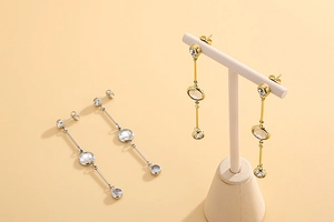Detail of long drop tassel earrings in gold and silver finish with sparkling crystals