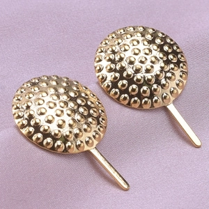 Close-up of golden 304 stainless steel round stud earrings with granulated dot texture