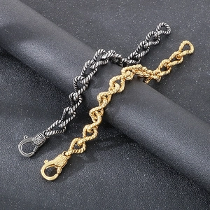 Detail of vintage punk twisted curb chain bracelets in gold and silver finish