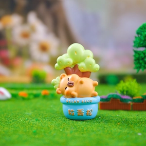 Macro shot of a cute orange resin animal figurine relaxing on a blue Relax Club flower pot