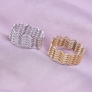 Close-up of wavy multilayer 304 stainless steel rings in polished gold and silver finishes