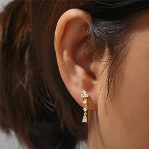 Macro shot of 925 sterling silver long drop earrings with white zircons on a model