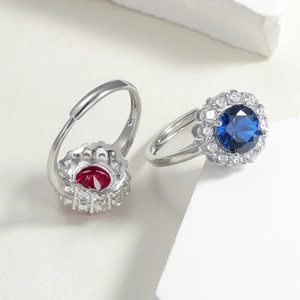 Close-up of luxury red corundum and blue spinel rings with glittering diamond halo stones
