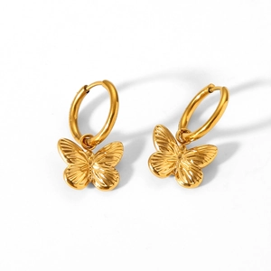 Detailed close-up of golden butterfly hoop earrings with fine wing texture on white background