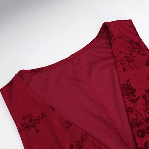 Détail du tissu en velours floral rouge foncé et de la couture du col en V sur une robe