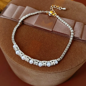 Detailed view of silver chain bracelet with white pearls and sparkling cubic zirconia