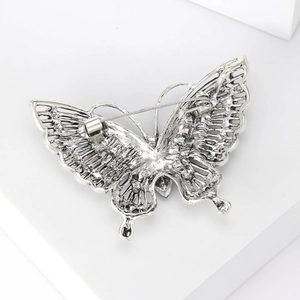 Vintage silver butterfly brooch with detailed bionic texture on a minimalist white background