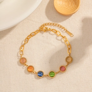 Vue détaillée du bracelet en acier doré orné de six perles colorées en œil de chat