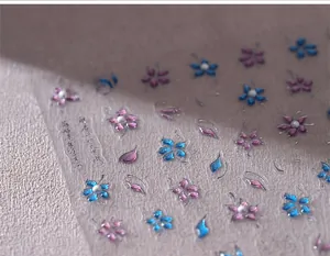 Vista macro dettagliata di adesivi per unghie 3D con fiori sbalzati e calligrafia elegante