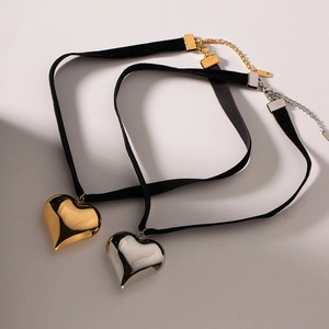 Détail de pendentif en forme de cœur sur tour de cou noir réglable en or et argent