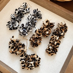 Elegant leopard print fabric petal tassel earrings and hoop earrings in wooden tray