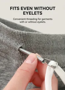 Close-up of flexible stainless steel threading tool passing through grey fabric