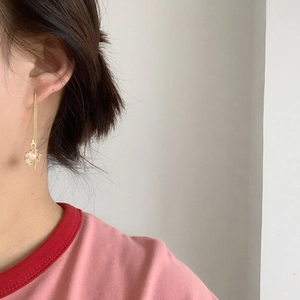 Elegant gold plated long chain earrings with cat-eye stone worn by a female model