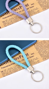 Dettaglio di portachiavi in pelle intrecciata viola e azzurro con anelli in metallo lucido