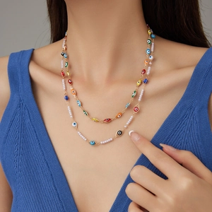 Collier double rang avec perles et pendentifs œil maléfique sur chaîne dorée
