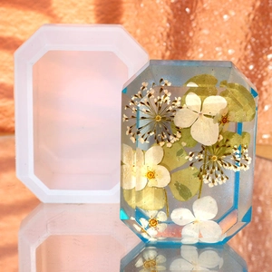Detail view of emerald cut silicone mold with finished crystal resin and dried white flowers