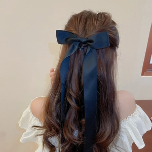 Rear view of long black mesh ribbon bow hair clip on a elegant half-up hairstyle