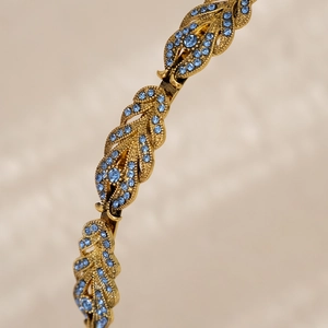 Close-up of blue rhinestones on a vintage gold leaf headband with detailed craftsmanship