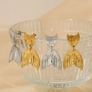 Boucles d'oreilles queue de poisson en acier inoxydable poli en or et argent sur verre