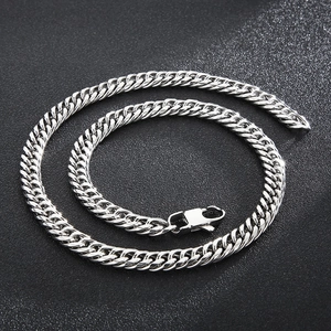 Detail shot of silver Cuban link chain necklace with lobster clasp on dark background